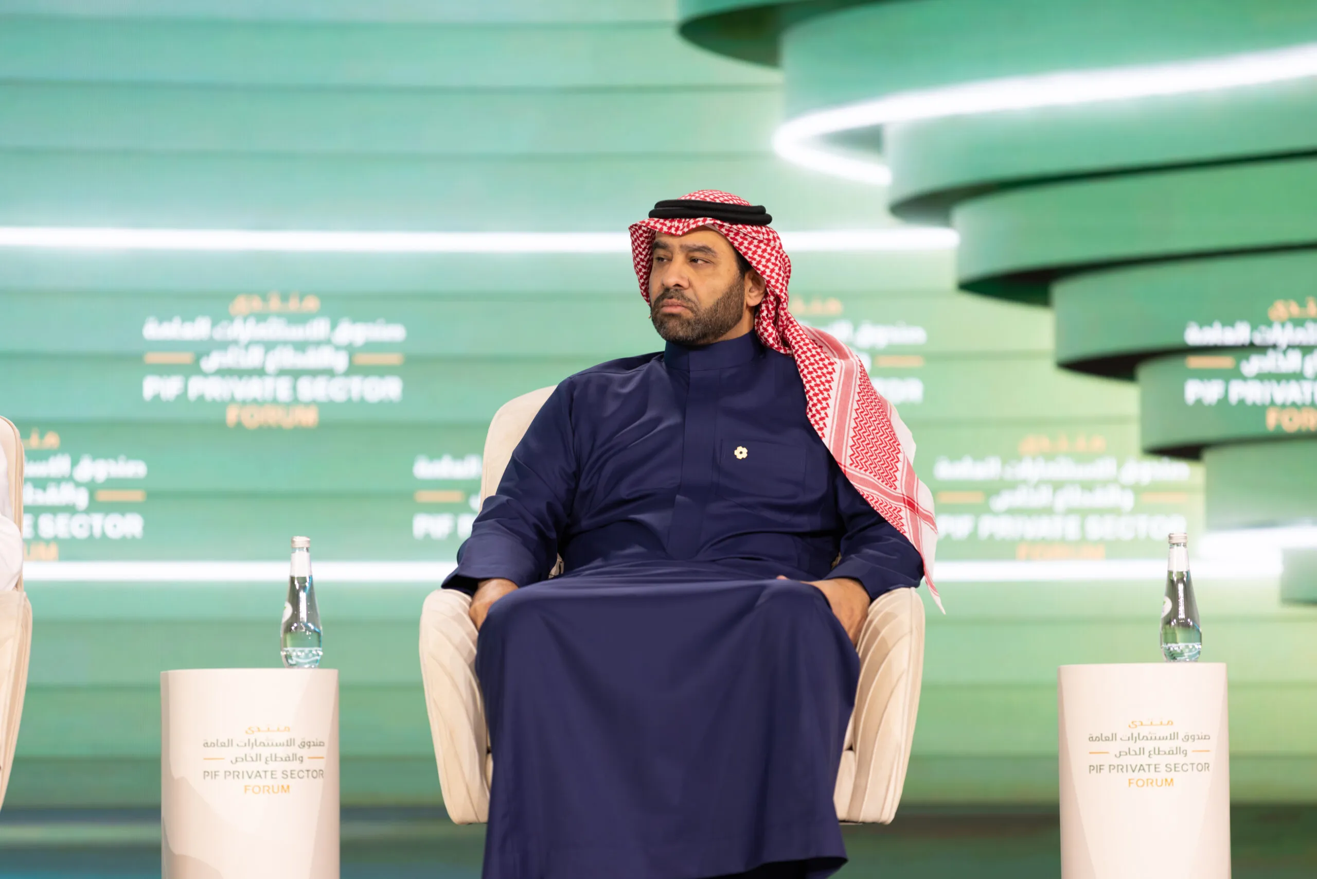 A speaker seated on the PIF Private Sector Forum stage