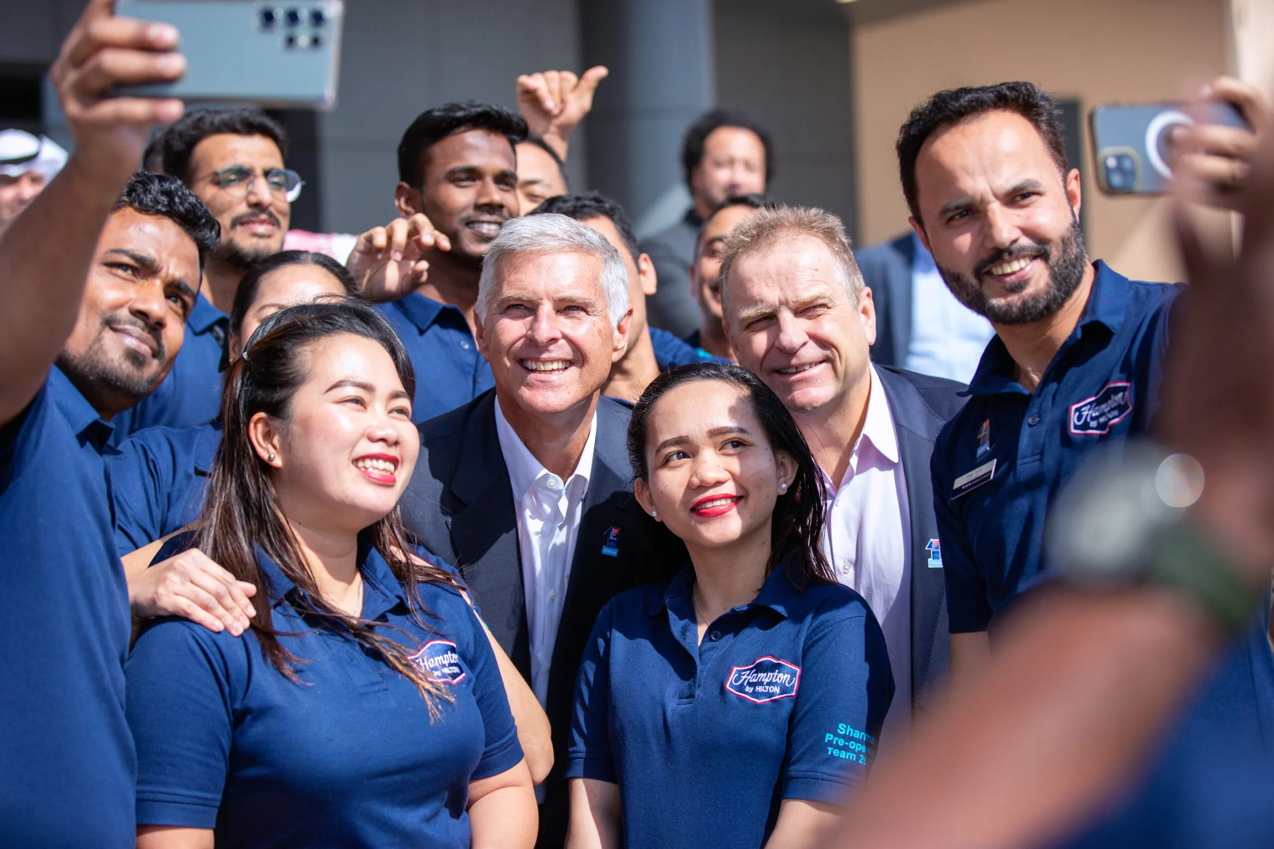 Hotel staff crowding in for a selfie outside the Hampton by Hilton