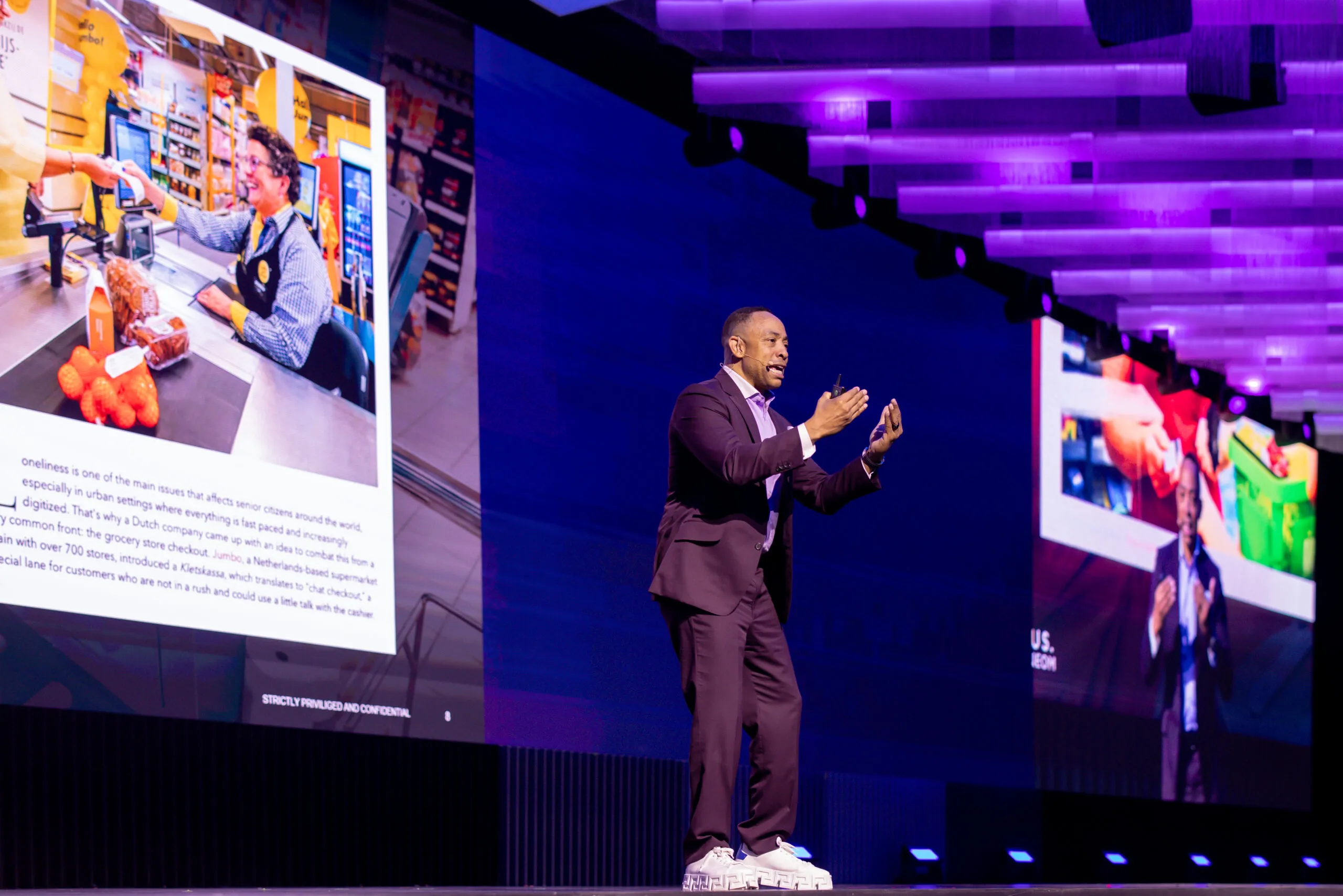 A speaker presenting between the video walls of the LEAP stage
