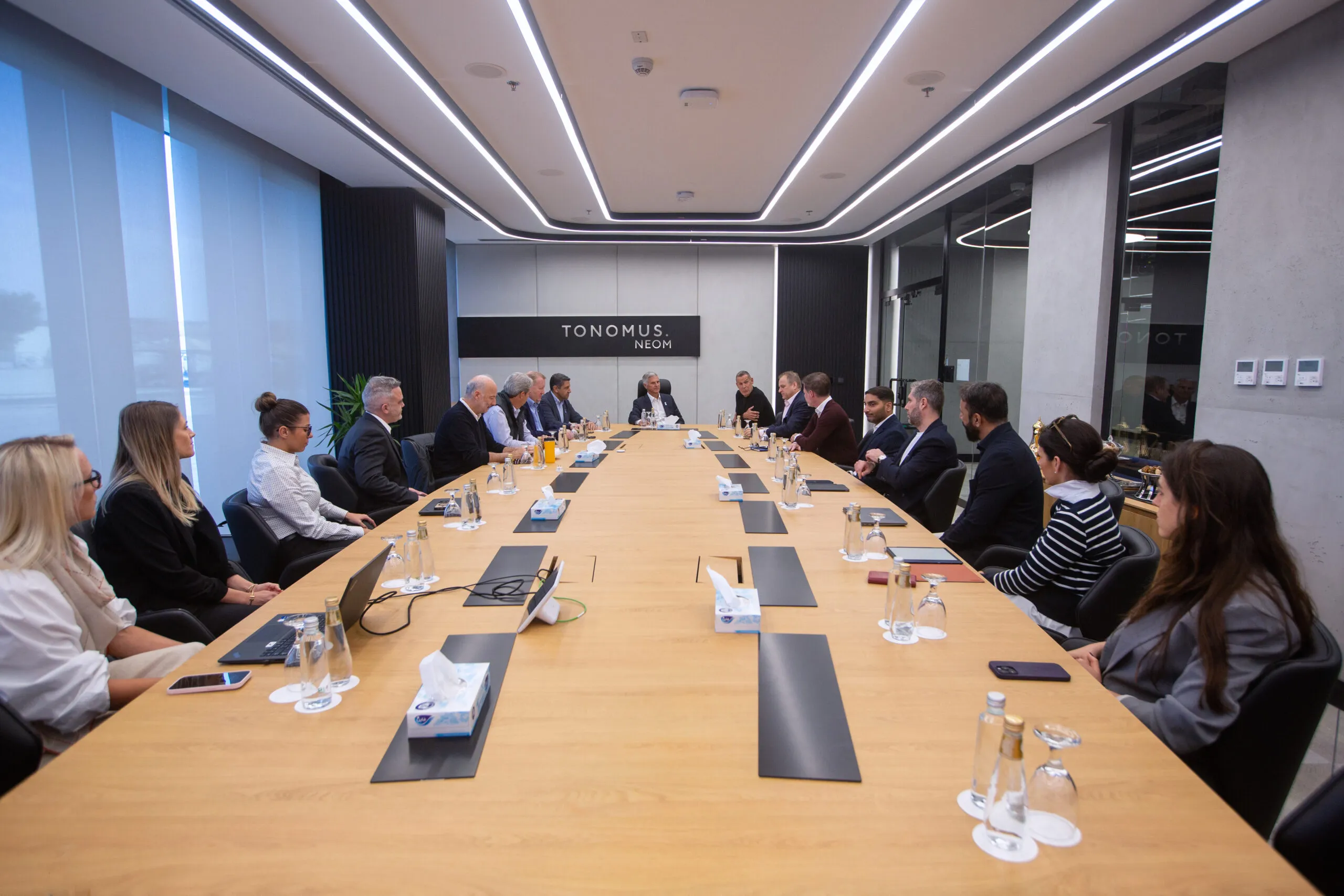 Delegates seated along both sides of the boardroom table during the visit
