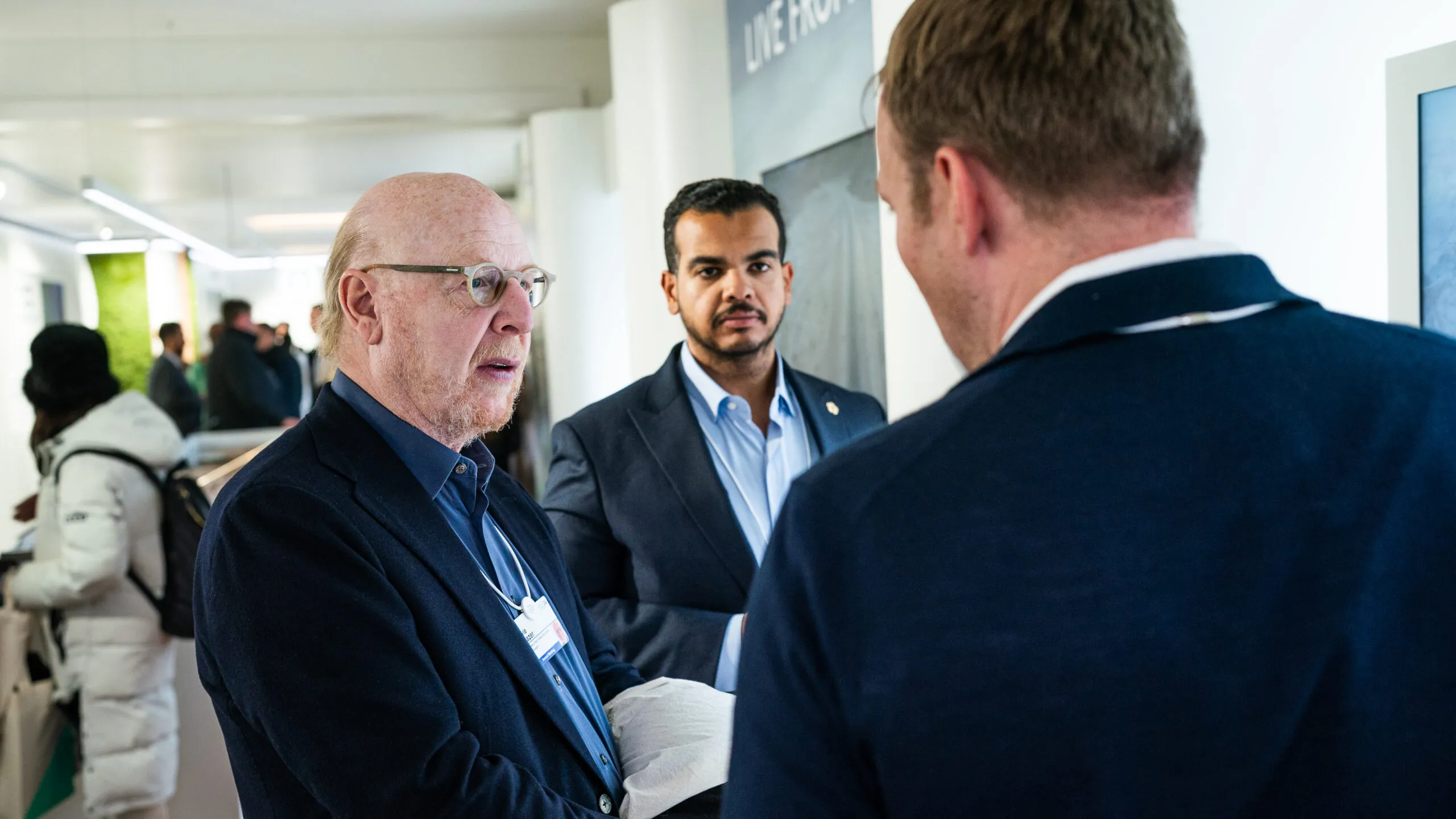 Three delegates in conversation inside the pavilion