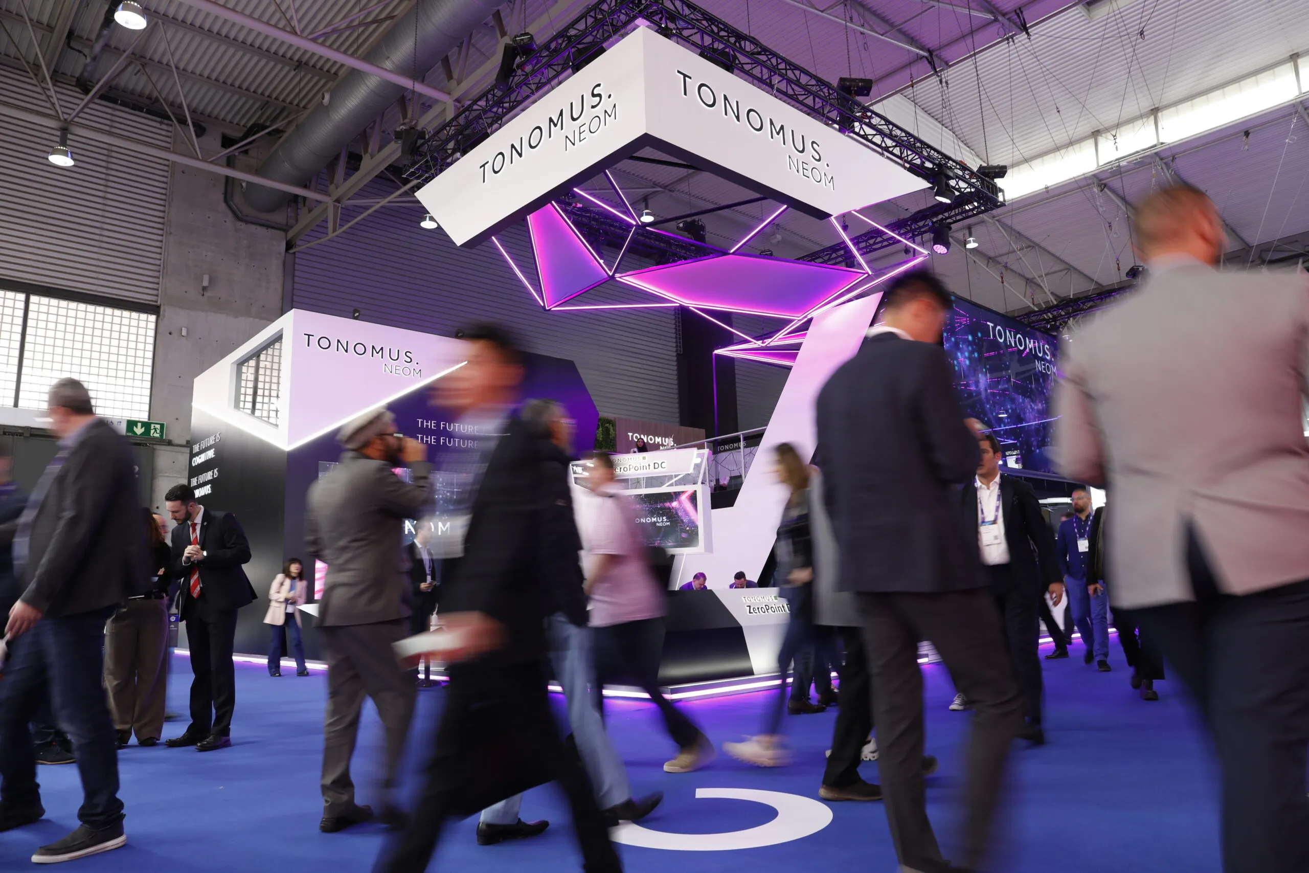 Crowds passing the TONOMUS NEOM booth in the exhibition hall