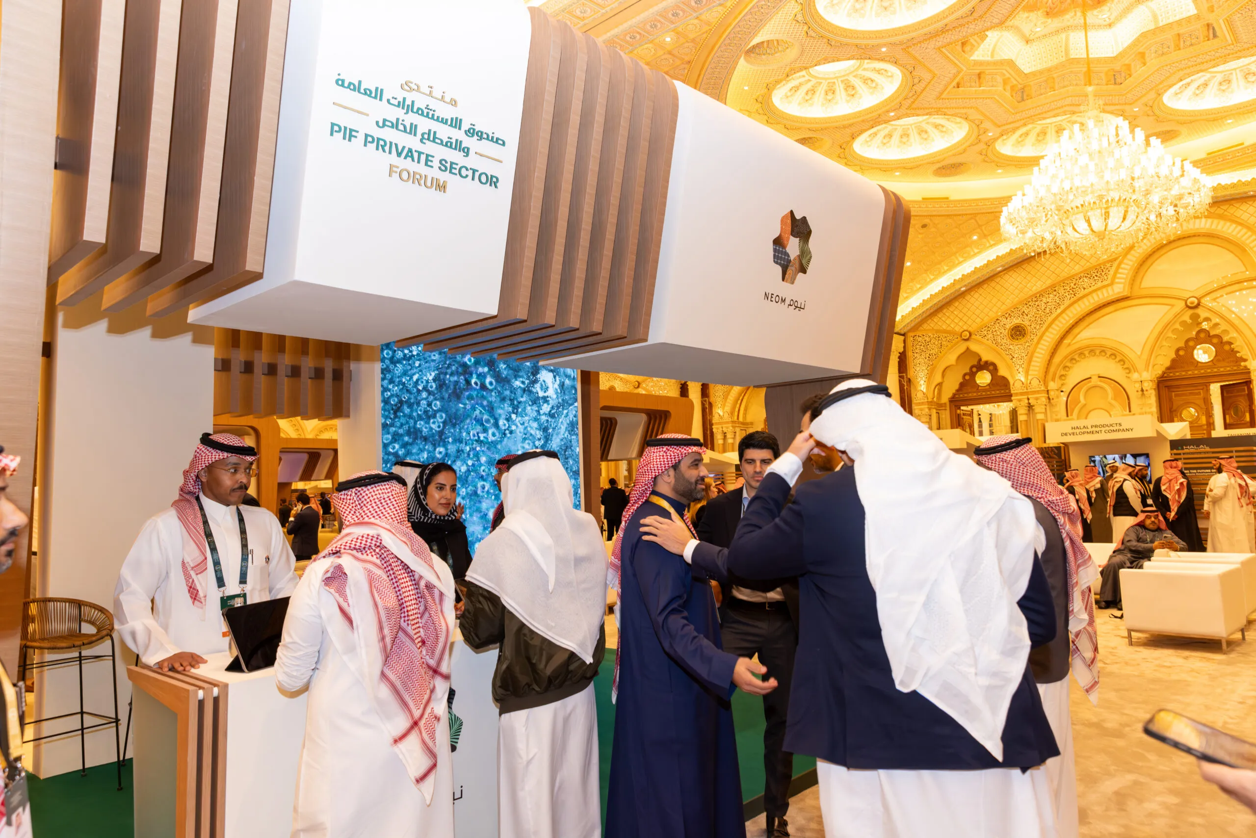 Visitors and staff talking at the booth's welcome desk