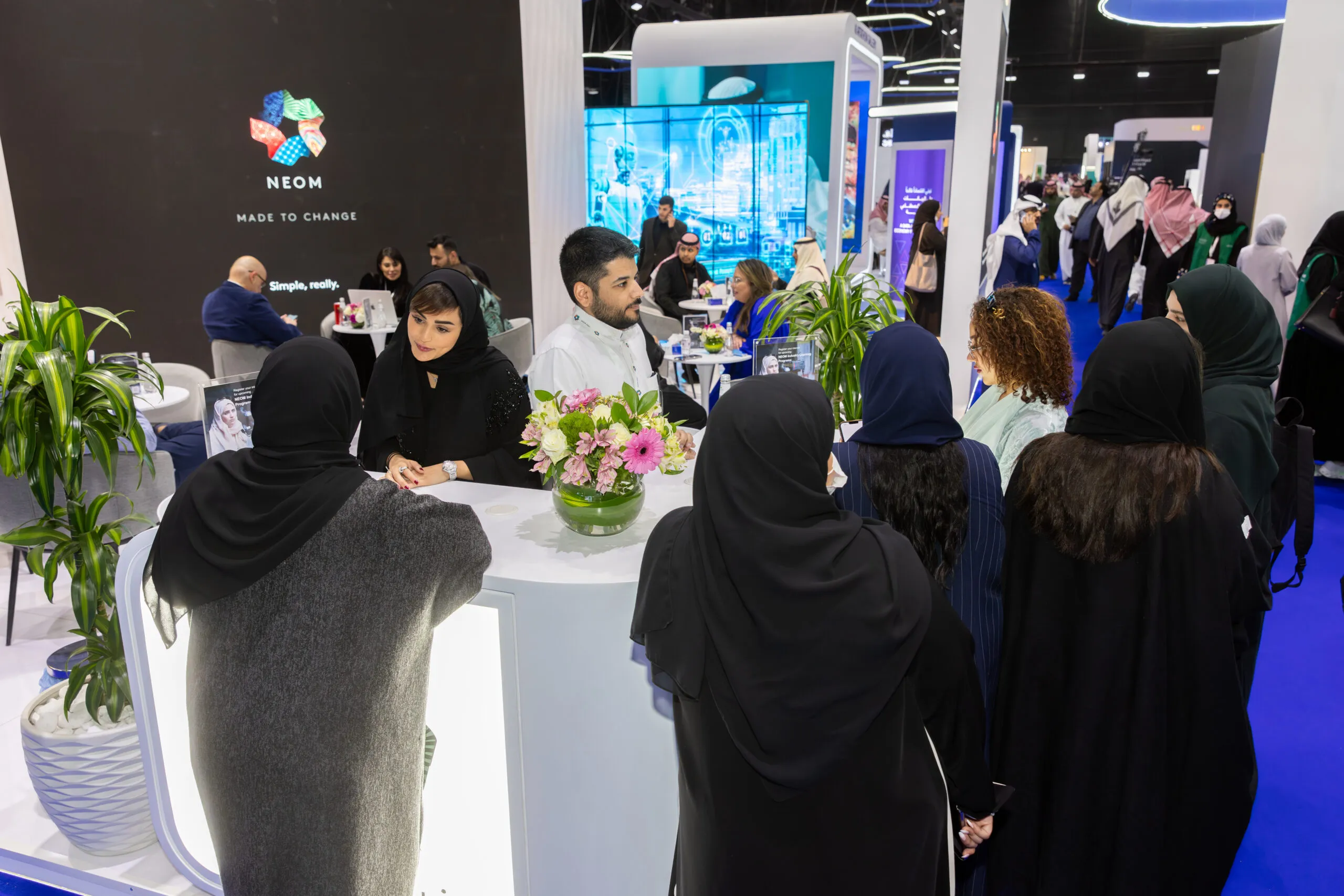 Visitors gathered around a table at the NEOM 'Made to Change' stand