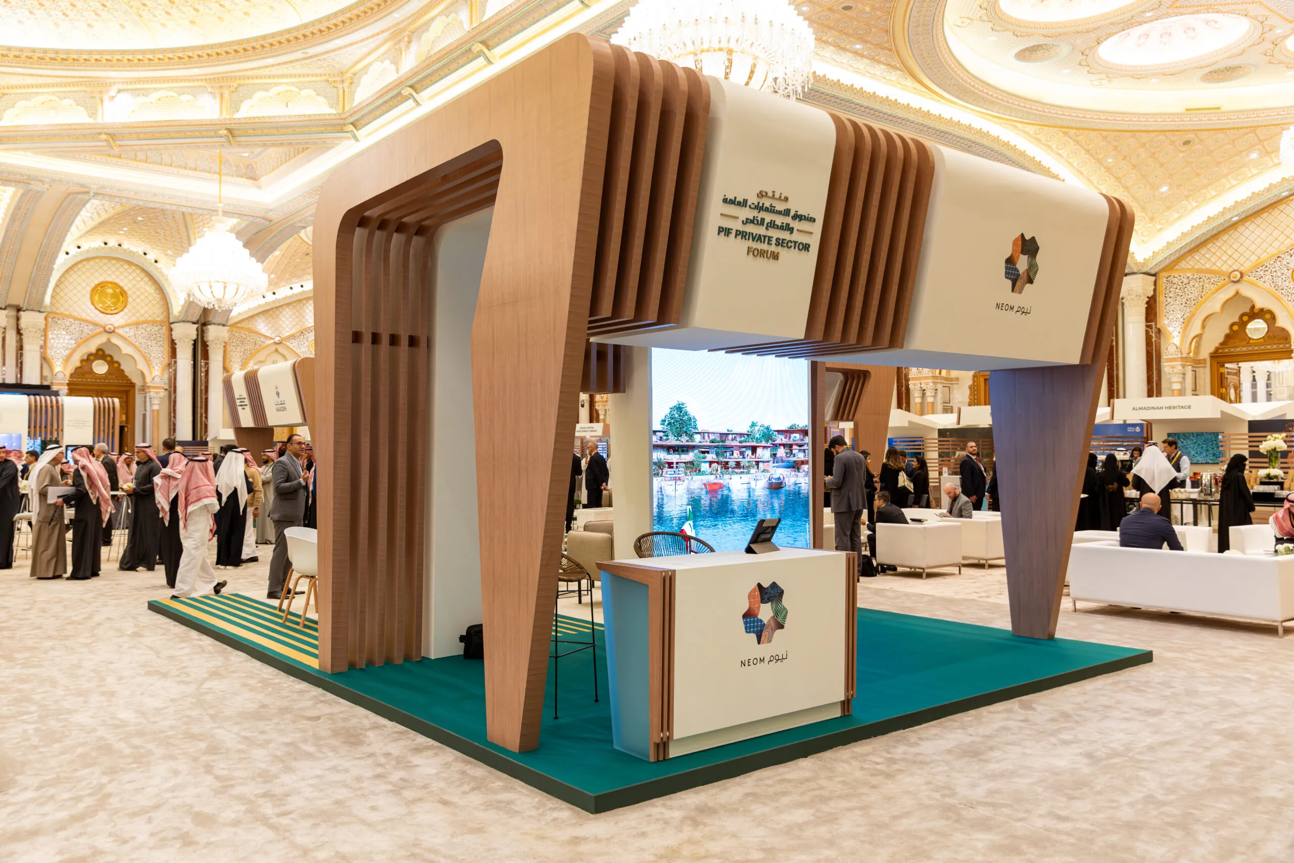 The NEOM booth — a slatted timber arch over a teal floor — in the ornate forum hall