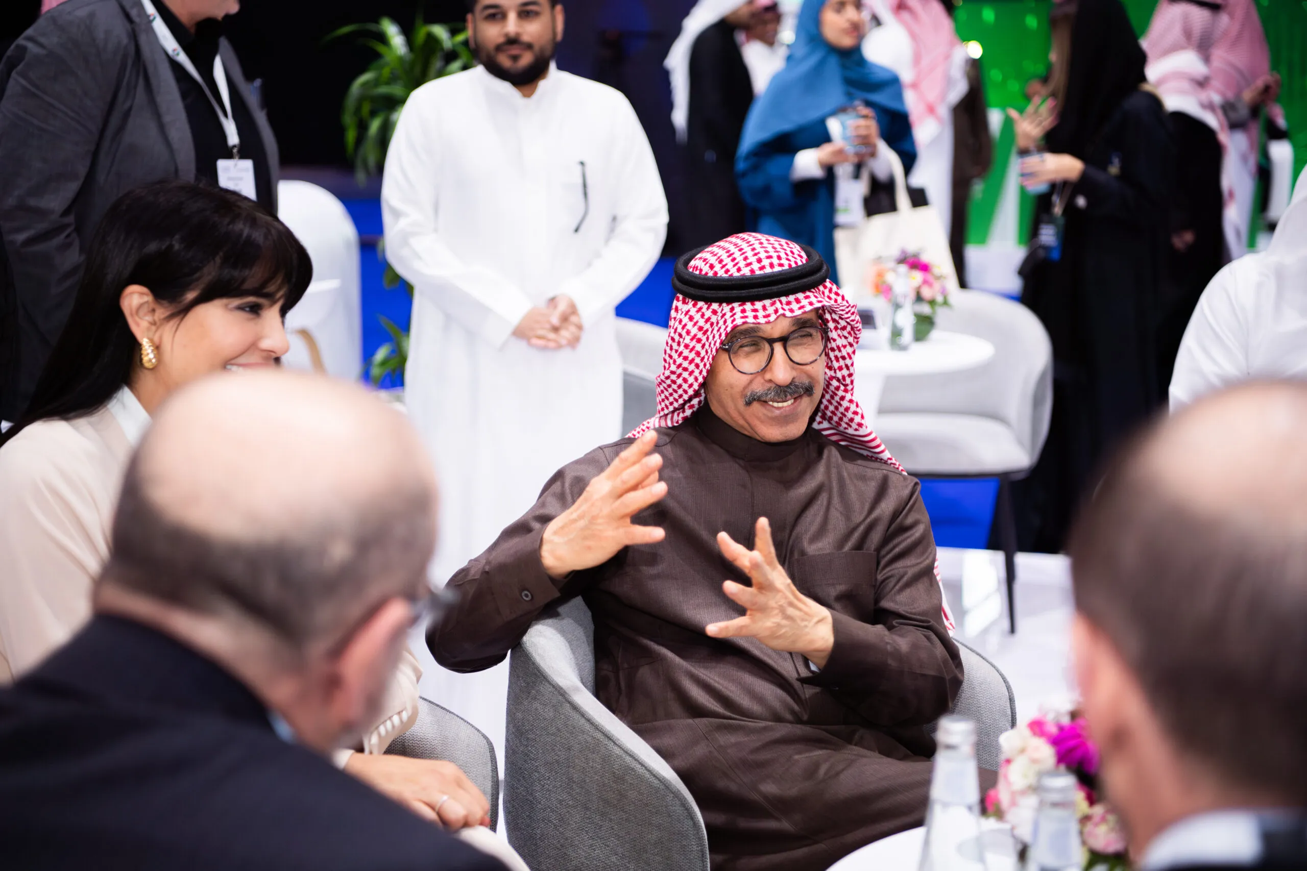 A man gesturing as he speaks with companions seated around him